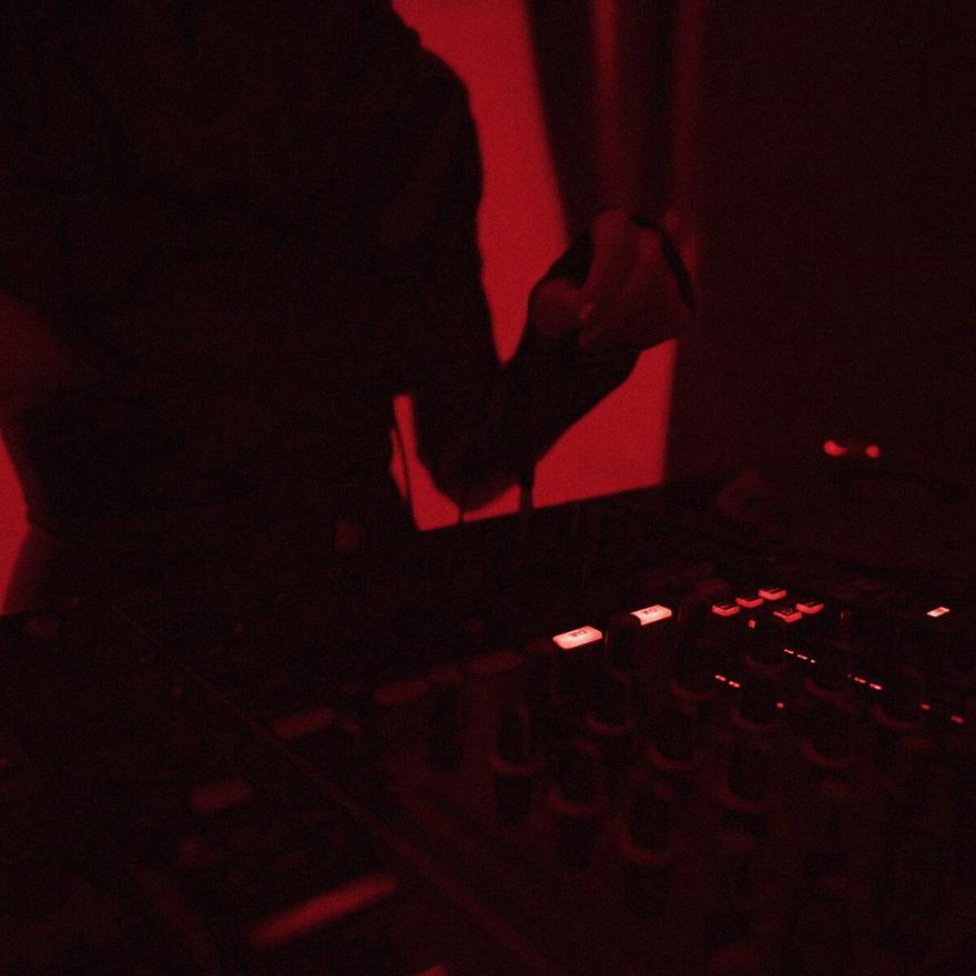 Arka ışıkta DJ kontrol masası ve yanan düğmeler