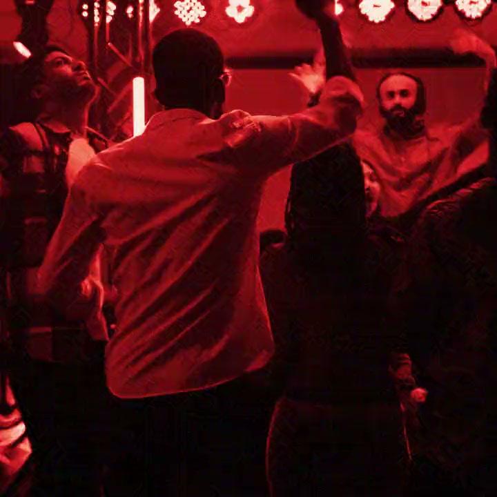 DJ kabininin önünde dans eden misafirler, kırmızı ışıkta